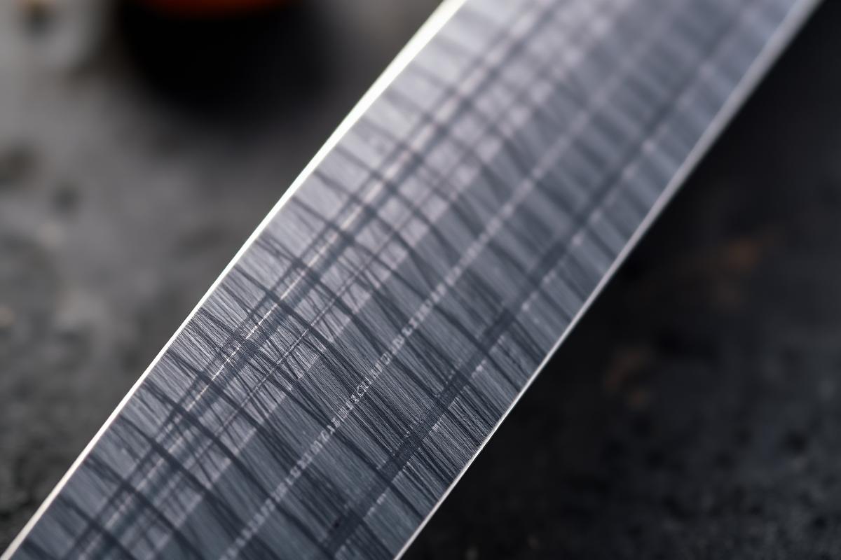 Gros plan sur le fil et la surface de la lame d'un couteau de cuisine japonais